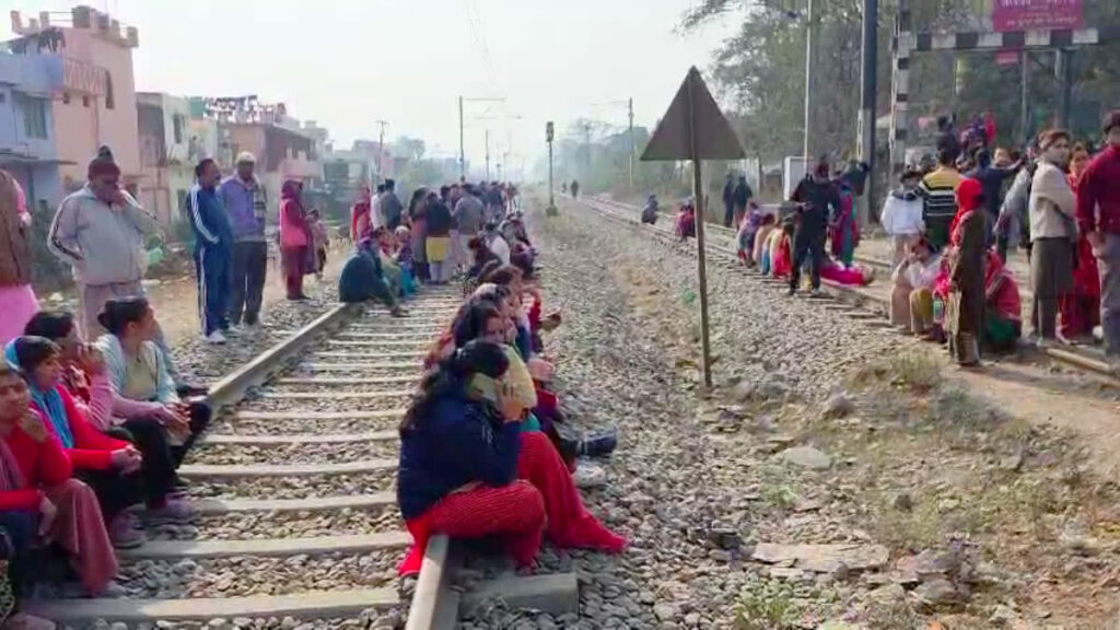 वन भूमि चिन्हीकरण की कार्रवाई के विरोध में रेलवे ट्रैक पर बैठे सैकड़ों लोग